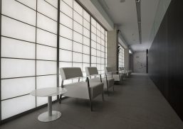 Translucent wall system featuring Kalwall panels in a modern interior space, with white seating and sleek design elements, emphasizing daylighting solutions for architectural applications.