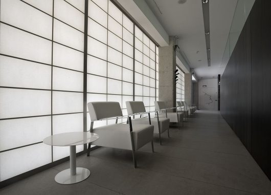 Translucent wall system featuring Kalwall panels in a modern interior space, with white seating and sleek design elements, emphasizing daylighting solutions for architectural applications.
