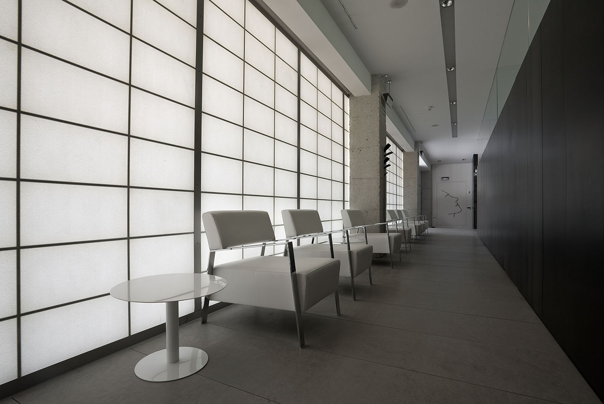 Dentist office interior in Pamplona, Spain, featuring Kalwall wall system with white chairs in front