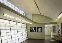 Interior of the Marx Brain Imaging Center featuring translucent facades for optimal daylighting, with framed brain imaging scans on the walls, designed by JUNK Architects.