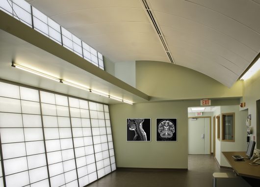 Interior of the Marx Brain Imaging Center featuring translucent facades for optimal daylighting, with framed brain imaging scans on the walls, designed by JUNK Architects.