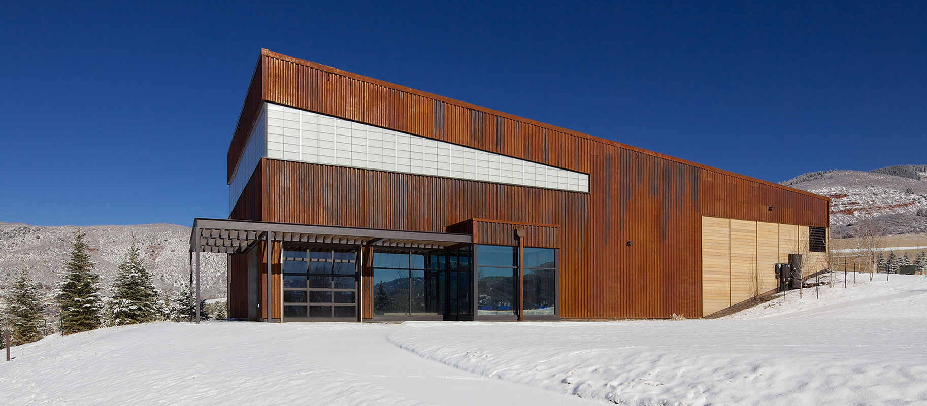 Exterior of Aspen Community School featuring Kalwall translucent cladding application surrounded by snowy Colorado landscape