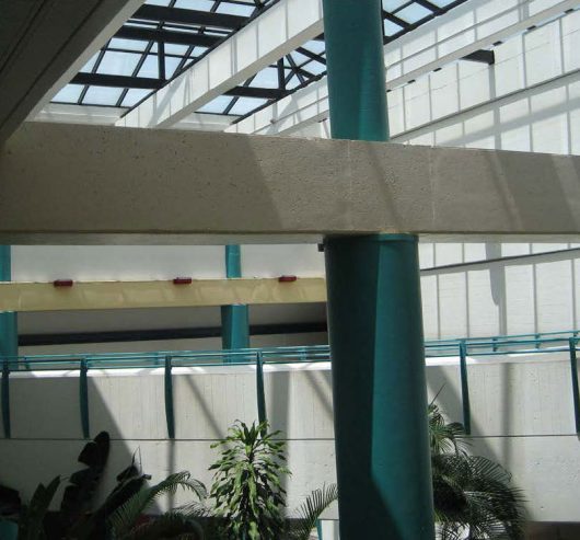 Interior of a building with glass skylights featuring glare on walls and columns