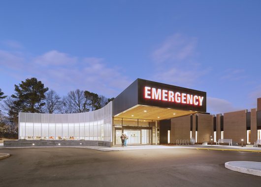 Curved Kalwall wall system of FRP panels on exterior of Methodist South emergency room at nighttime with backlighting
