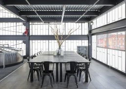 Kalwall facade application at Middle West Spirits showcased in office building with tables, chairs and industrial equipment