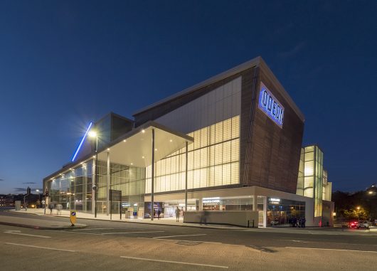 Building exterior at nighttime featuring building clad with Kalwall facade with Odeon written on side.