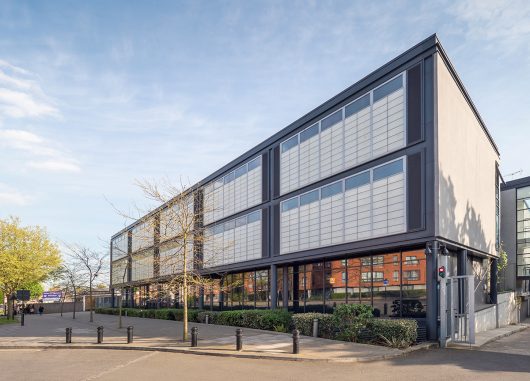 Window replacement by Kalwall on modern-looking Featherstone High School with green trees in front