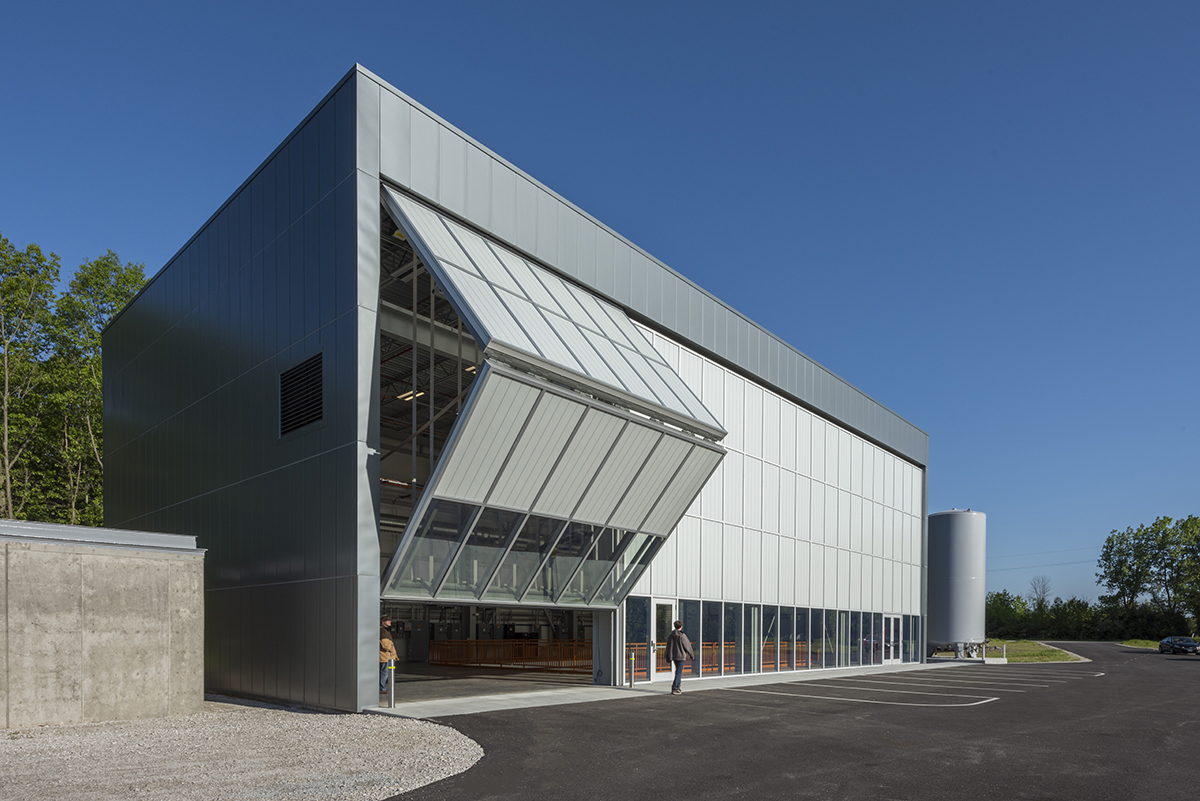 Fermilab exterior shot with unitized curtain wall system with one set of wall panels opening to reveal inside