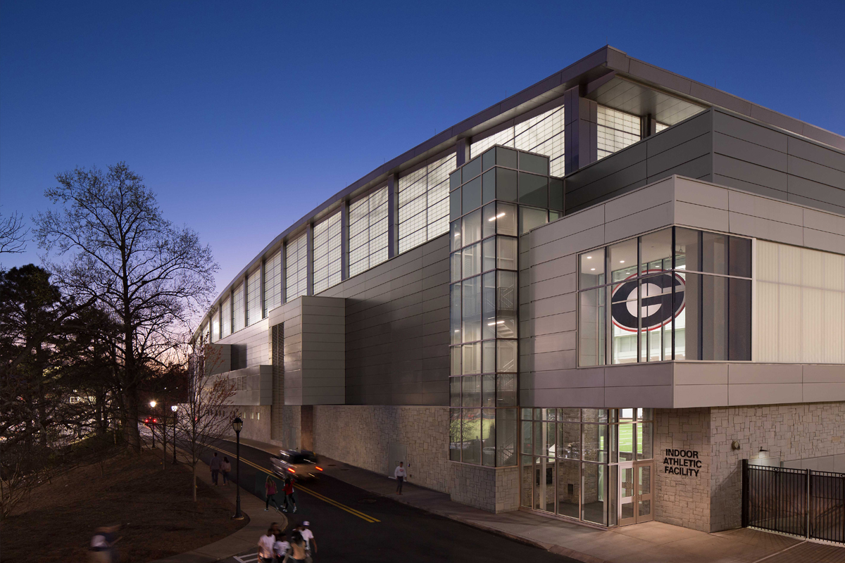 Nighttime exterior of University of Georgia indoor athletic facility featuring Kalwall FRP panels on upper third of building