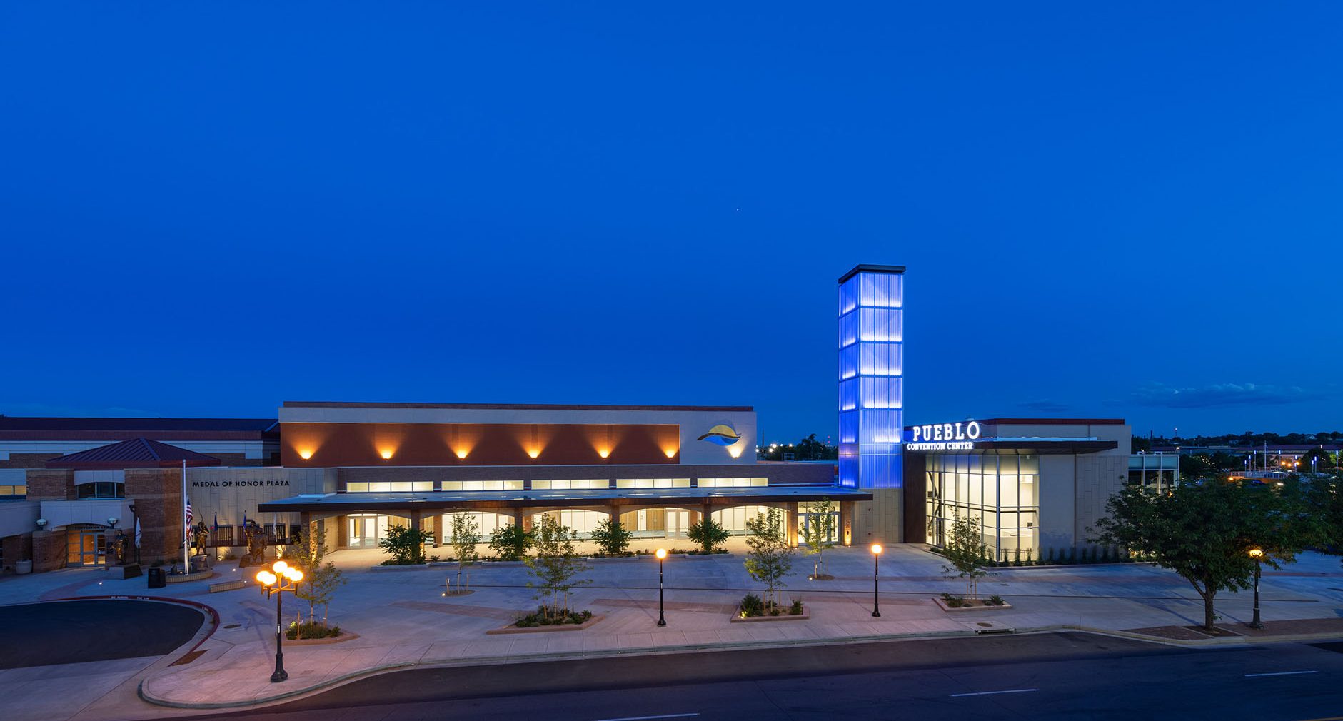 Pueblo Convention Center exterior at nighttime featuring blue backlighting on building tower with Kalwall facade.