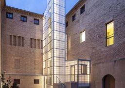 Exterior shot of building courtyard featuring light-colored brick building with Kalwall panel-clad tower.