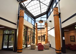 Building lobby with red and tan chairs, wooden columns and a Kalwall skylight creating perfectly diffuse daylight.