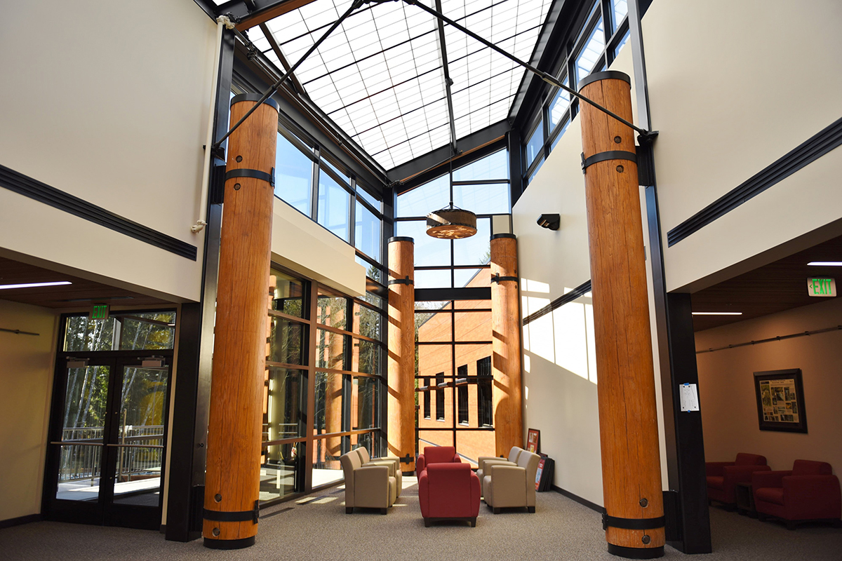 Building lobby with red and tan chairs, wooden columns and a Kalwall skylight creating perfectly diffuse daylight.