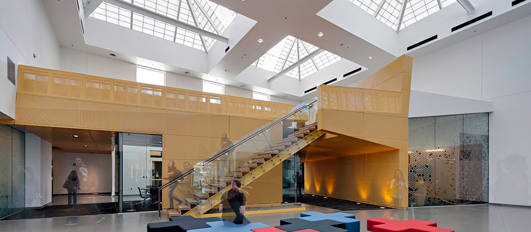 Students walking down staircase at Paradise Valley Community College with overhead lighting from multiple Kalwall skylights