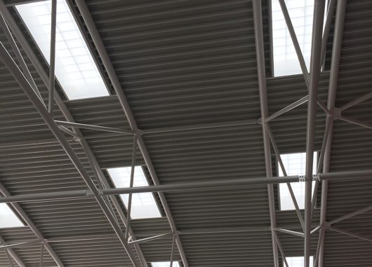 Close-up of Kalwall s-line skylights among metal piping in ceiling featured in the Cheltenham Ladies' College interior.