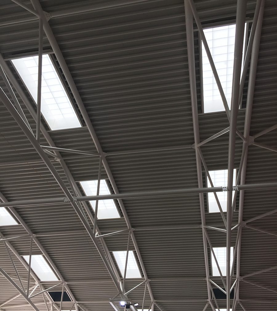 Close-up of Kalwall s-line skylights among metal piping in ceiling featured in the Cheltenham Ladies' College interior.