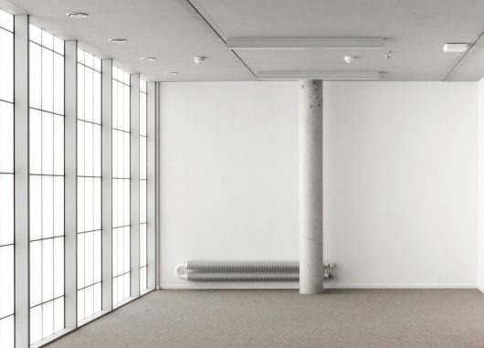 Industrial Design Center at Howest interior of room with white walls, white floor, pole in room and Kalwall facade.