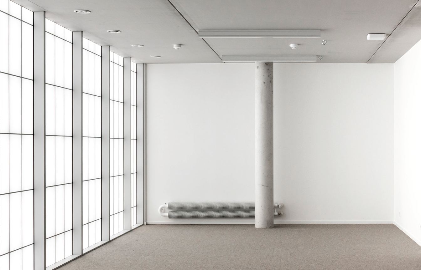 Industrial Design Center at Howest interior of room with white walls, white floor, pole in room and Kalwall facade.