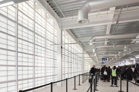 People in security line at Glasgow International Airport in Scotland, with Kalwall facade to provide security and privacy