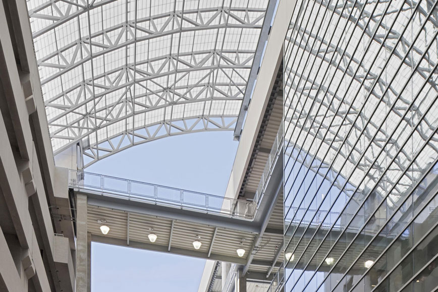 Close-up of East River Plaza shopping center featuring curved Kalwall skyroof® application over walkway connecting buildings