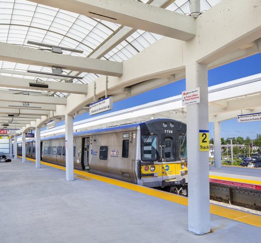 View of the Long Island Railroad Hicksville Station featuring a train and a Kalwall commercial canopy over standing area