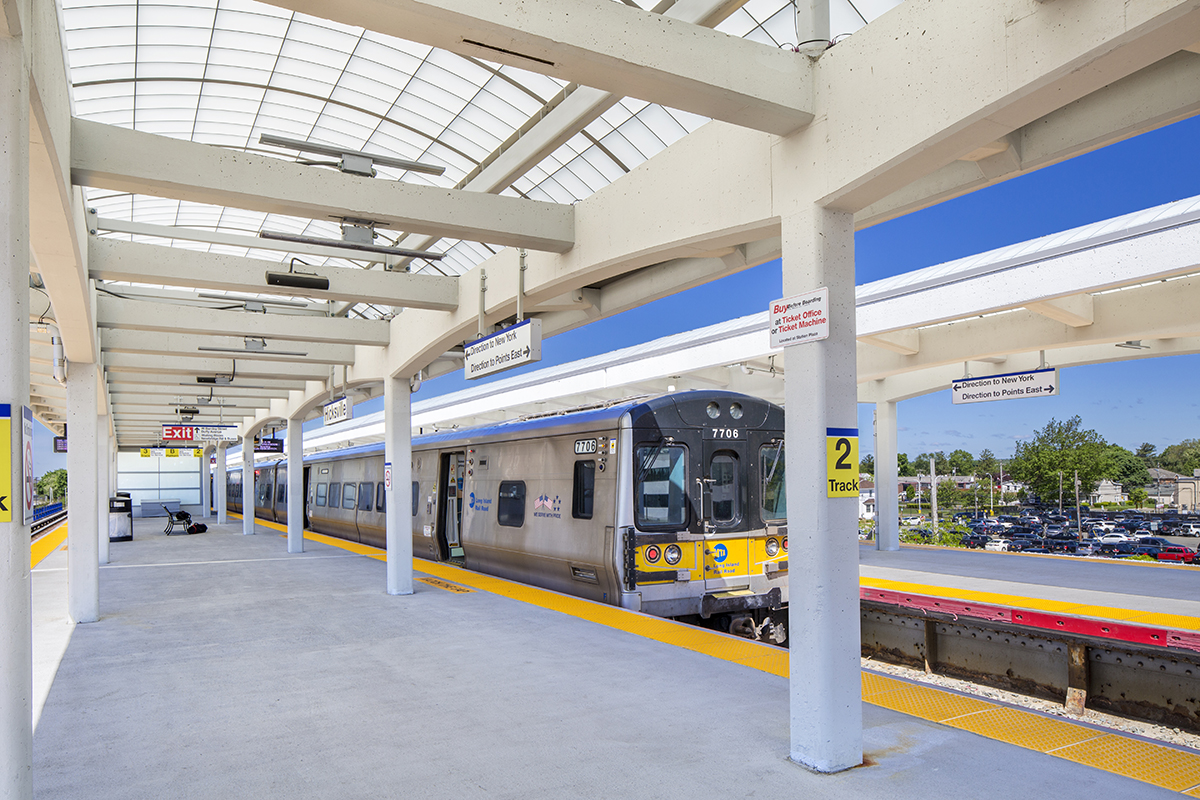 View of the Long Island Railroad Hicksville Station featuring a train and a Kalwall commercial canopy over standing area