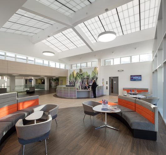 Benenden Hospital atrium and lounge area with tables and chairs featuring skylight windows with Kalwall structural panels