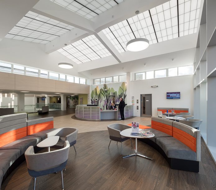 Benenden Hospital atrium and lounge area with tables and chairs featuring skylight windows with Kalwall structural panels