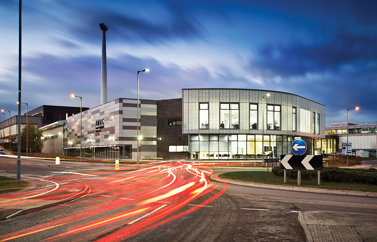 Building exterior at nighttime with blurred sky and blurred car lights featuring Kalwall unitized curtain wall panels