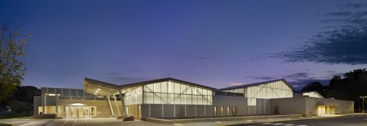 Building exterior at nighttime against dark blue sky featuring backlighting from Kalwall curtain wall system