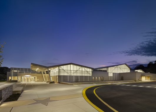 Building exterior at nighttime against dark blue sky featuring backlighting from Kalwall curtain wall system