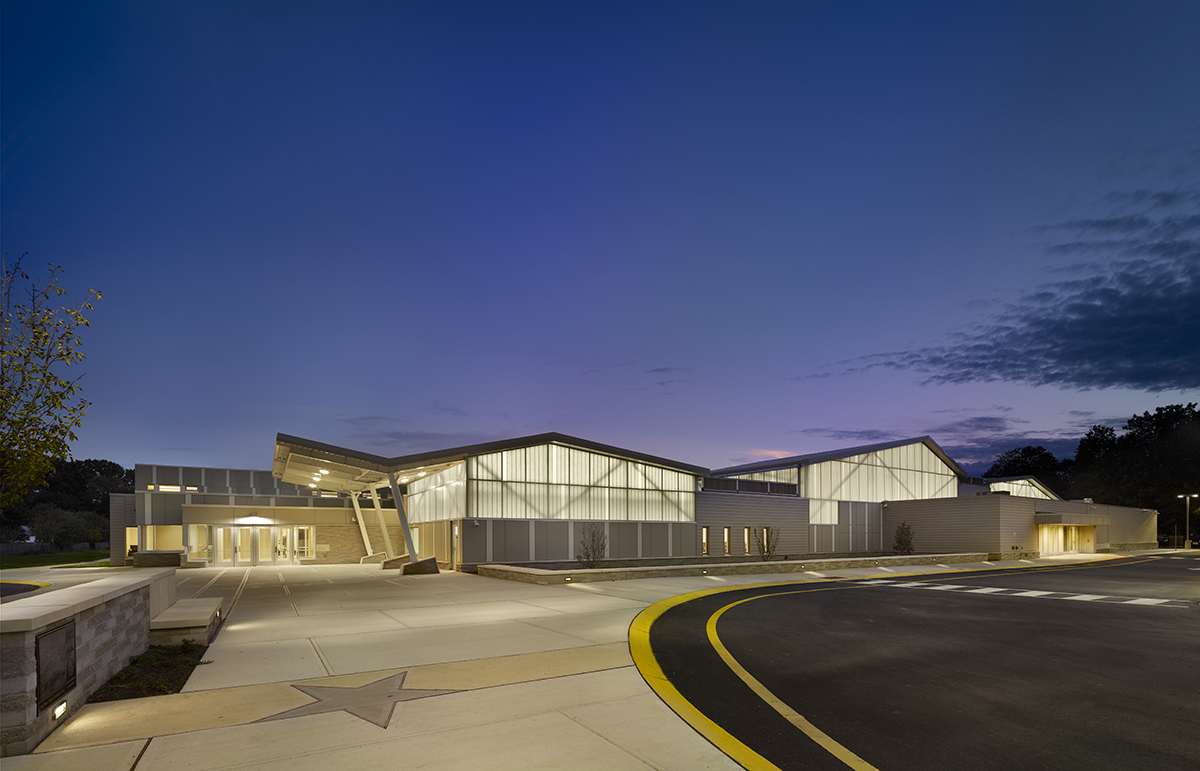 Building exterior at nighttime against dark blue sky featuring backlighting from Kalwall curtain wall system