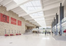 Dunbar High School interior with brick walls and students walking beneath Kalwall skylight system with white ceiling panels