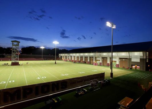 Florida State football practice facility exterior with green field and stadium lights with building with Kalwall FRP panels