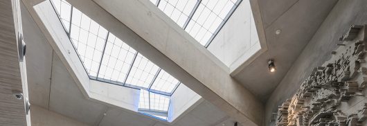 Interior looking up at Kalwall removable skylight with translucent daylighting surrounded by concrete ceiling and beams