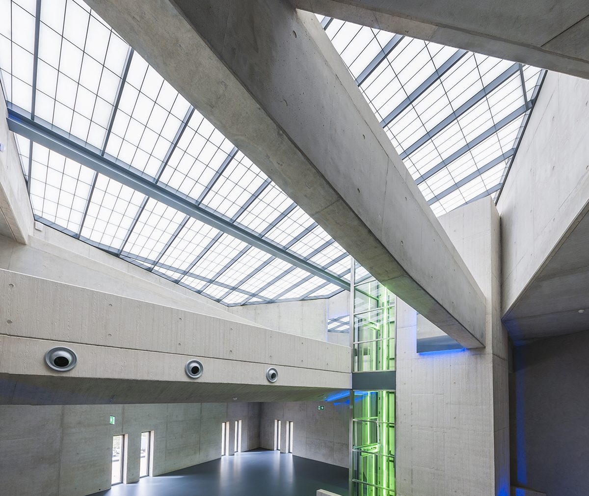 Kalwall skyroof® application in geometric-shaped building with green and blue glowing lights