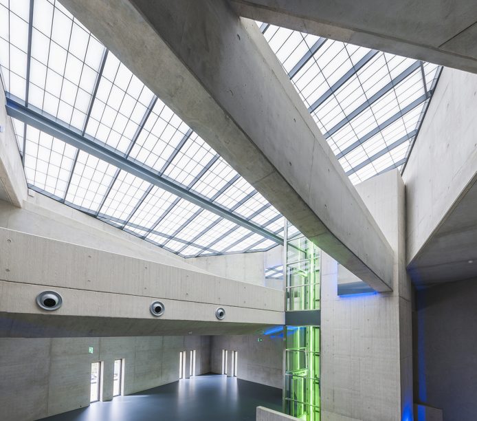 Kalwall skyroof® application in geometric-shaped building with green and blue glowing lights