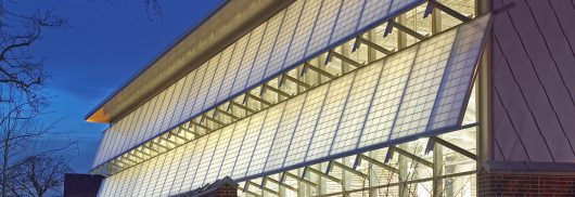 Germantown School exterior at nighttime featuring well-lit Kalwall panels in two canopy sections.