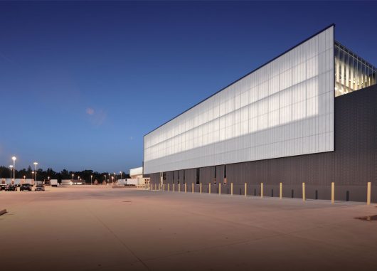 Nighttime exterior of Dollar General Distribution Center featuring Kalwall curtain wall system with translucent daylighting