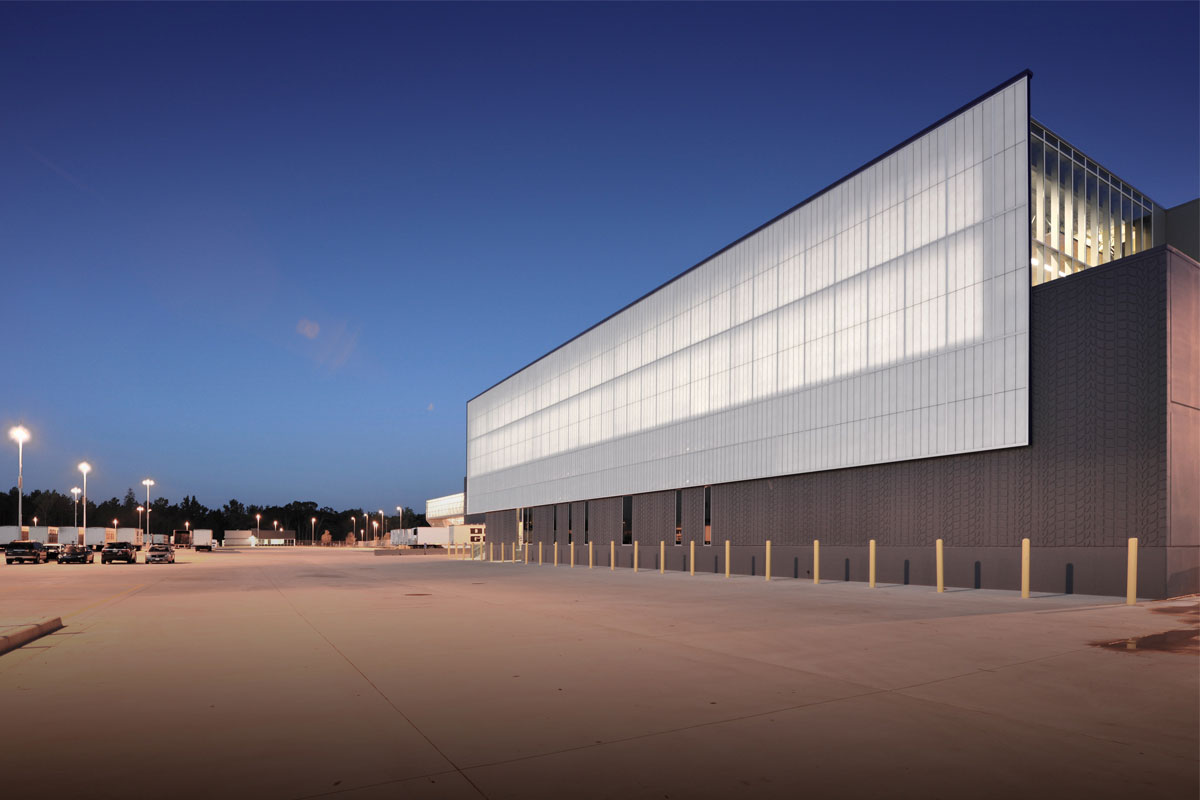 Nighttime exterior of Dollar General Distribution Center featuring Kalwall curtain wall system with translucent daylighting