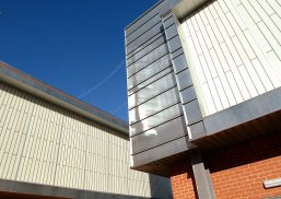 Brick building with Kalwall translucent facade system and metal paneling angled with another building with Kalwall panels