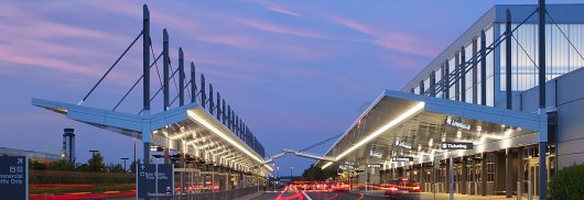 RDU airport exterior showcasing Kalwall Vertikal™ grid pattern on curtain wall system at sunset with blurred lights from cars