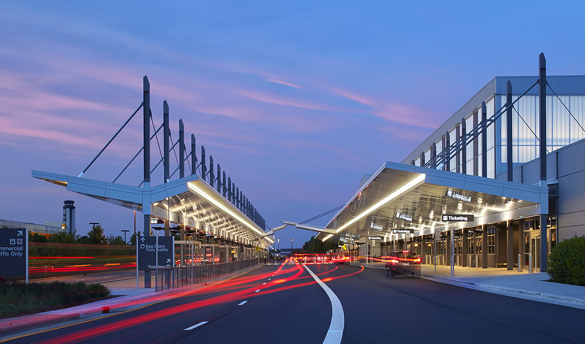 RDU airport exterior showcasing Kalwall Vertikal™ grid pattern on curtain wall system at sunset with blurred lights from cars