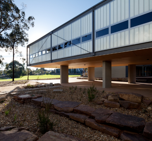 Tintern Middle School exterior featuring raised building with Kalwall facade and unitized panels surrounded by rock garden
