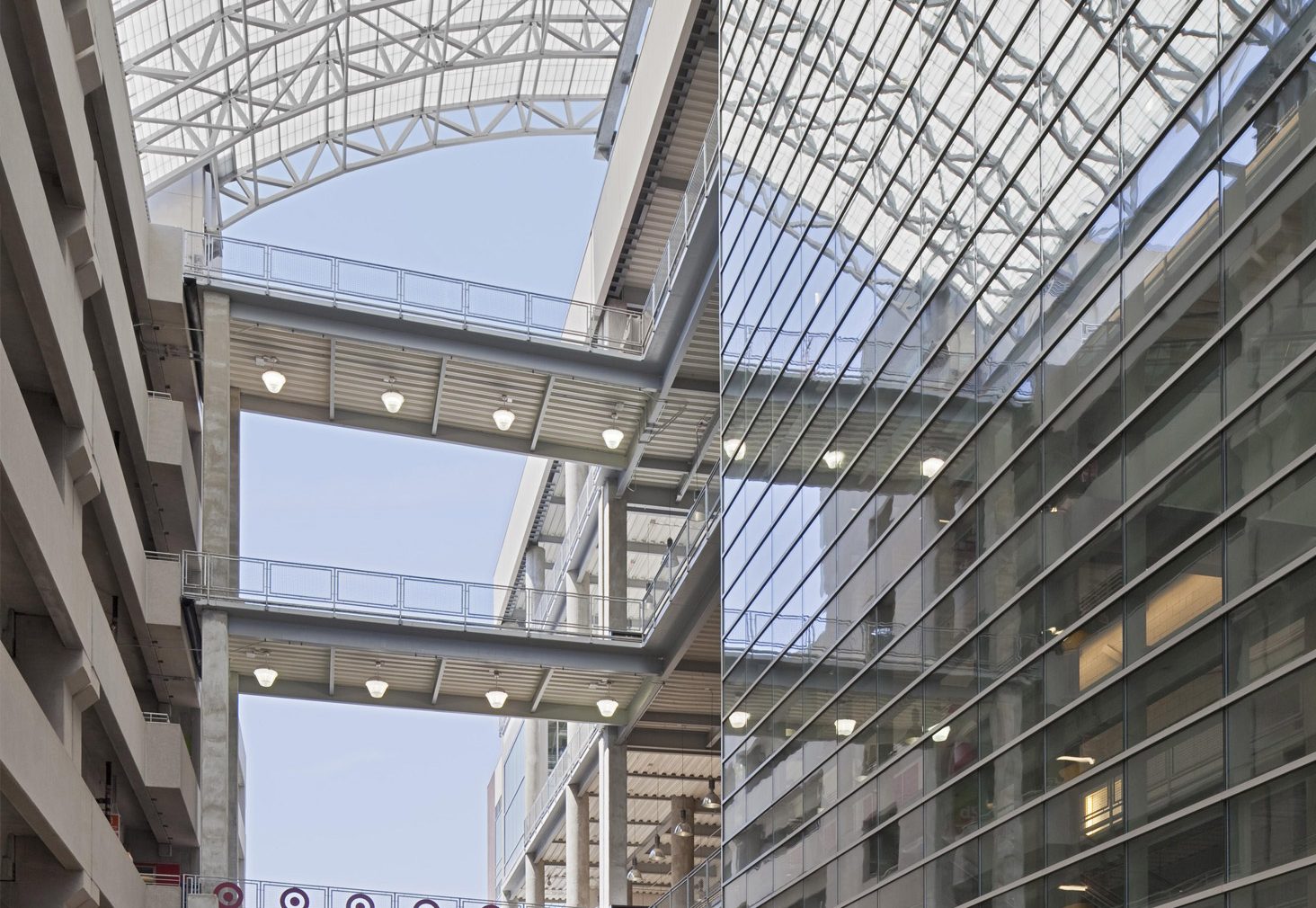 Multistory parking garage for shopping center featuring curved Kalwall skyroof® application over walkway connecting buildings