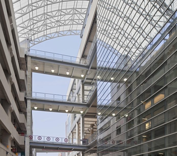 Multistory parking garage for shopping center featuring curved Kalwall skyroof® application over walkway connecting buildings
