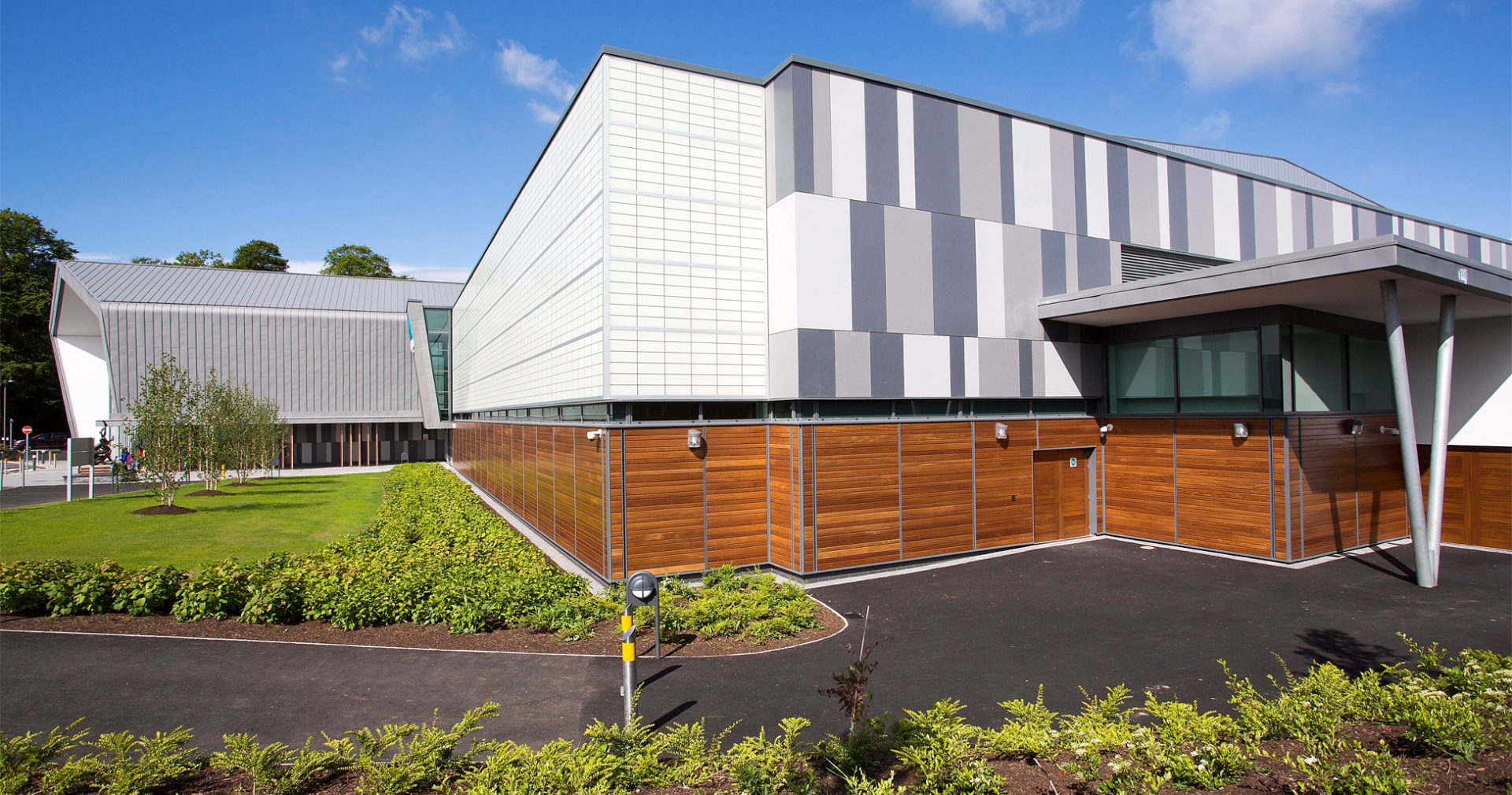 Foyle Arena exterior set against bright blue sky featuring wooden and white and gray paneling and translucent Kalwall facade