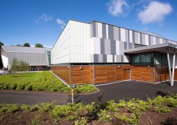 Foyle Arena exterior set against bright blue sky featuring wooden and white and gray paneling and translucent Kalwall facade