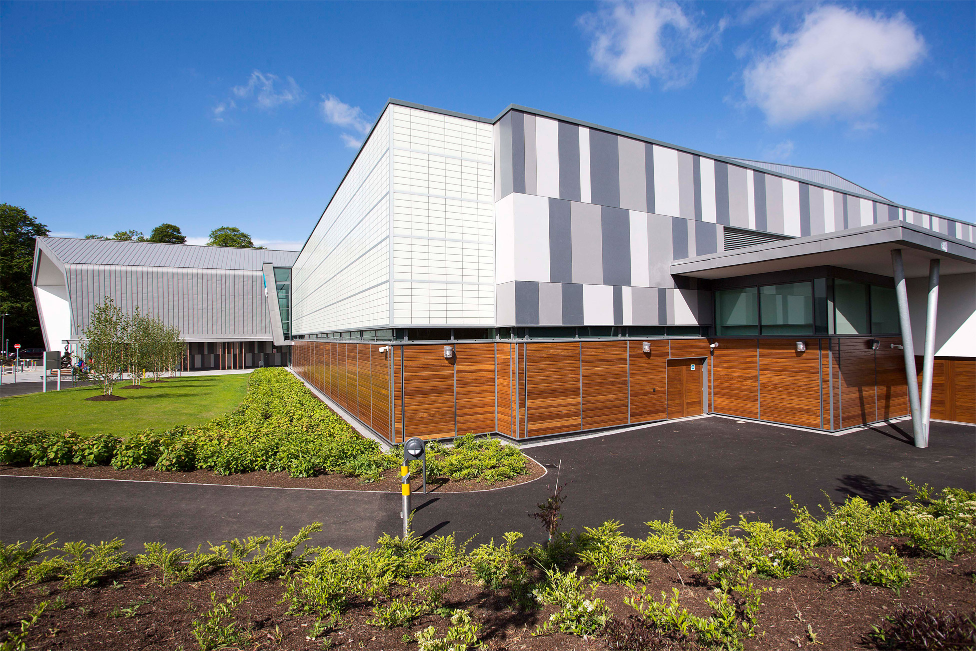 Foyle Arena exterior set against bright blue sky featuring wooden and white and gray paneling and translucent Kalwall facade