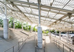 Rapid transit station in Ohio featuring sloped Kalwall translucent canopy over cinderblock columns and greenery in background